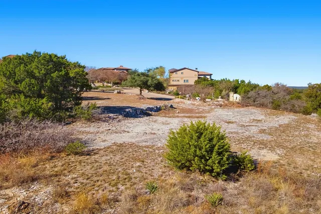 a view of a dry yard with wooden fence