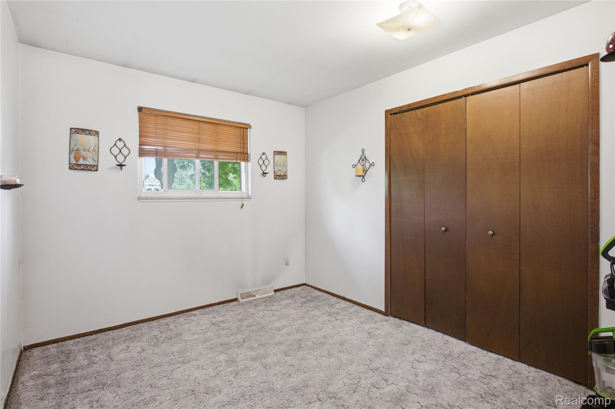 47395 Dequindre Road Rochester, MI 48307 - Photo 9 of 19 Room with a wood-finish bi-fold closet, white walls, and textured gray carpet