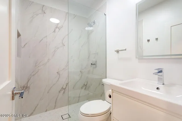 a bathroom with a toilet sink vanity and shower