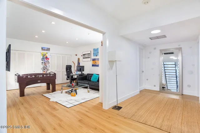 a living room with a couch and a dresser with wooden floor