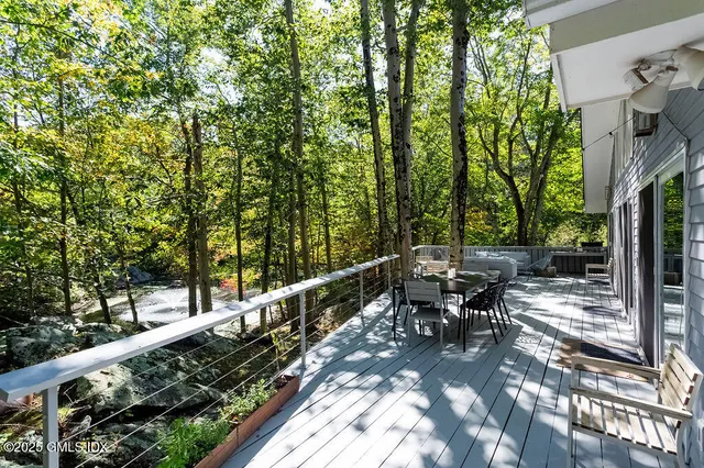 a view of a balcony with chairs and wooden fence