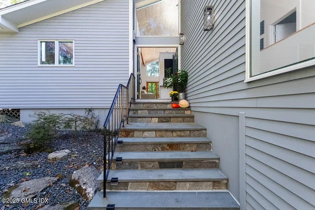 a view of a house with entryway and wooden stairs