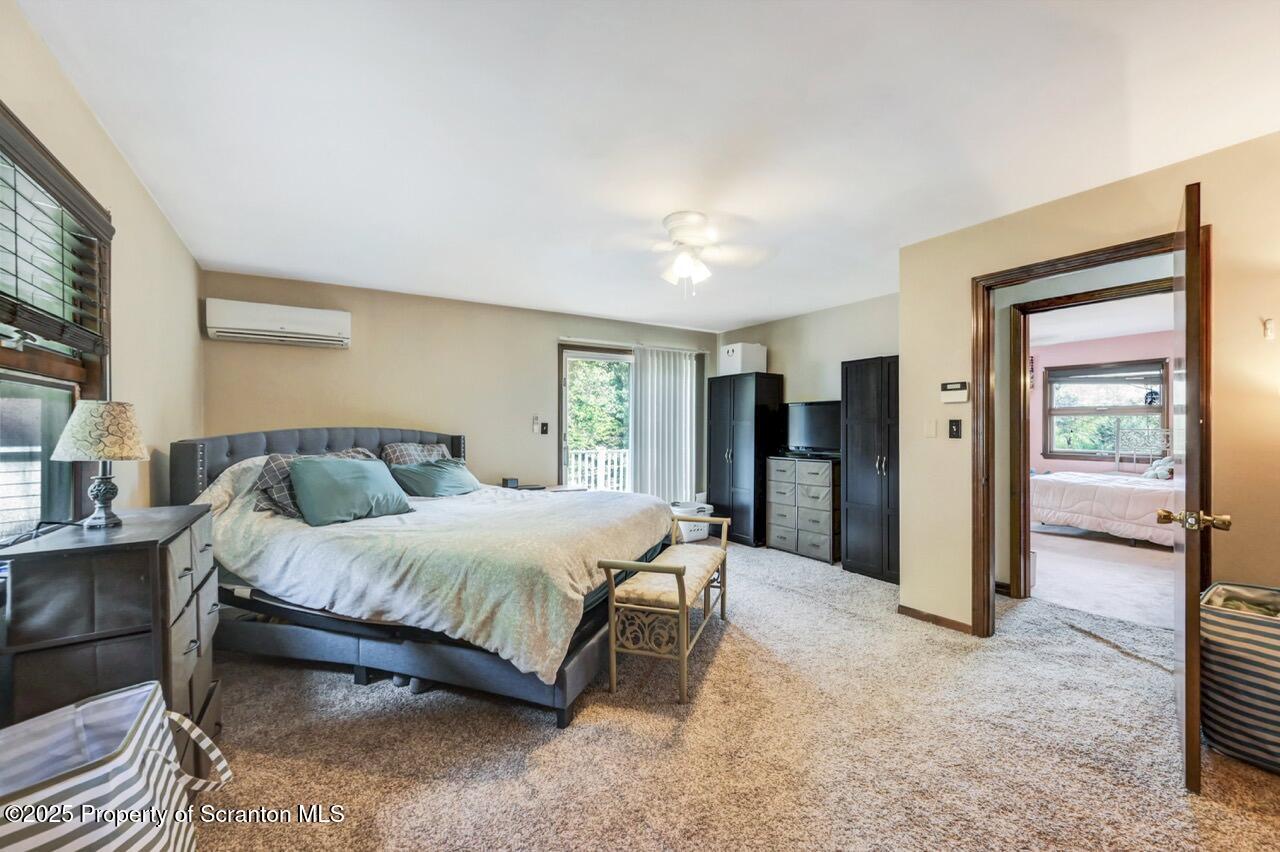 2352 Newton Ransom Boulevard Clarks Summit, PA 18411 - Photo 23 of 85 a spacious bedroom with a bed table and a large mirror