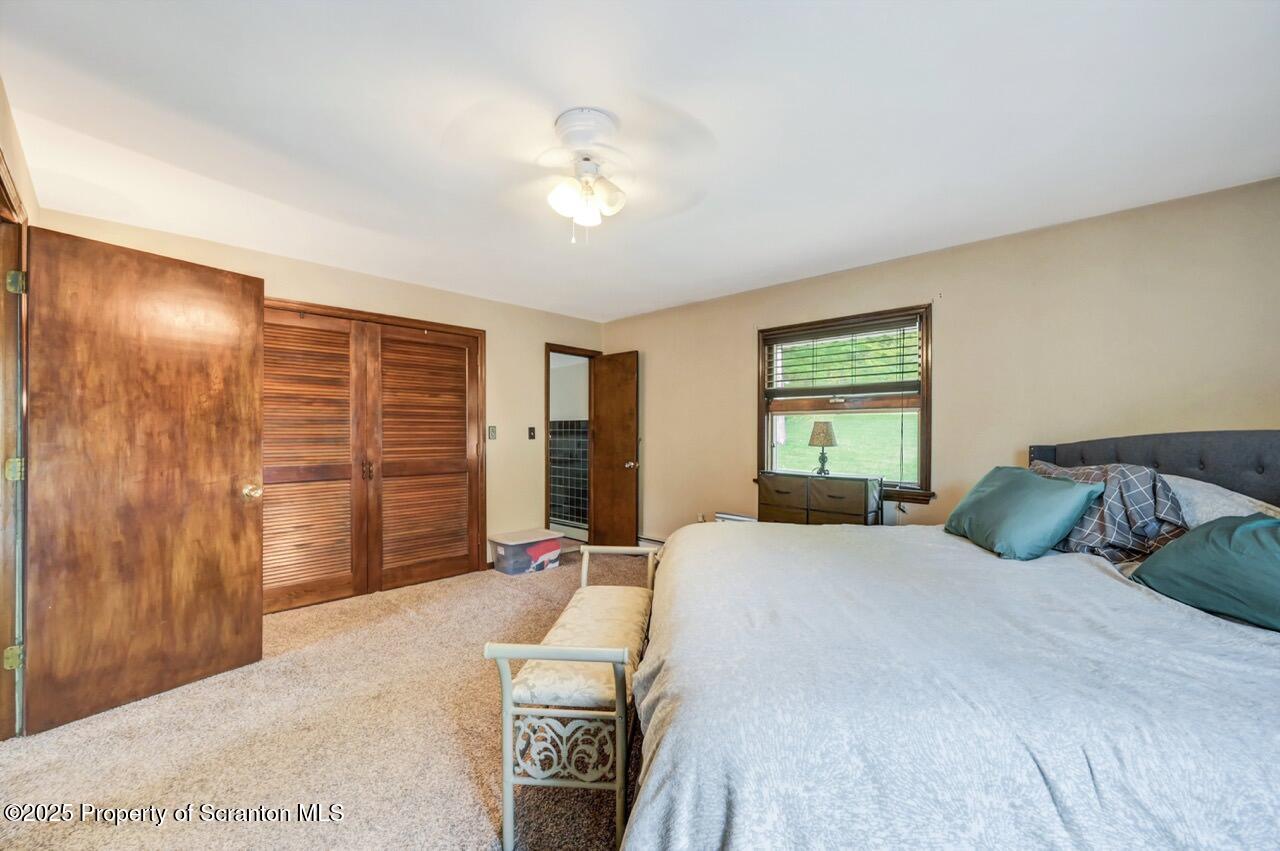 2352 Newton Ransom Boulevard Clarks Summit, PA 18411 - Photo 25 of 85 a bedroom with a large bed and a chandelier