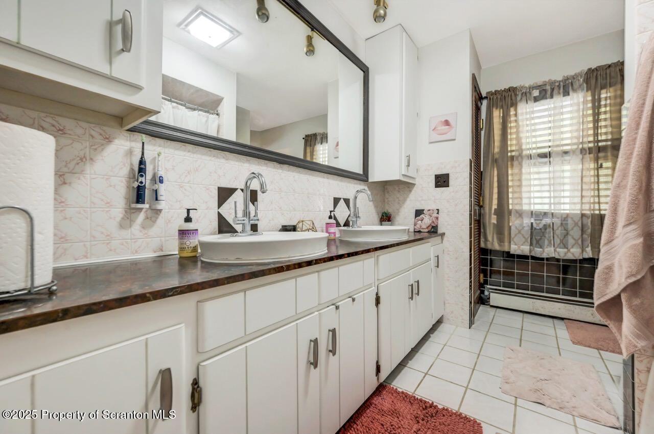 2352 Newton Ransom Boulevard Clarks Summit, PA 18411 - Photo 28 of 85 a spacious bathroom with a double vanity sink a mirror and next to a window