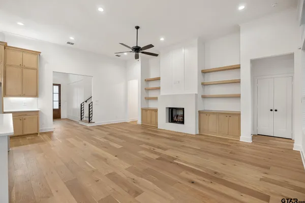 a view of empty room with wooden floor and window