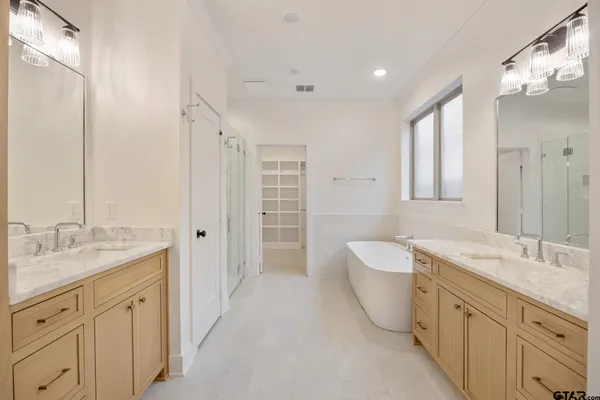 a spacious bathroom with a double vanity sink mirror double and bathtub