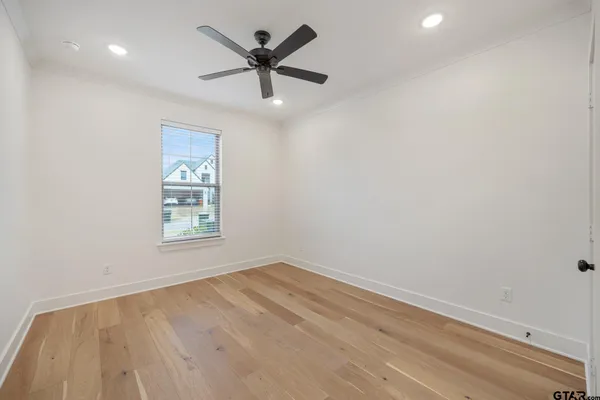 an empty room with a window and a fan