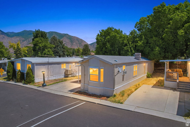 1525 South 400 East, Unit 13 Springville, UT 84663 - Photo 1 of 32 Front exterior featuring light-colored siding, a covered porch with wood railing, and a paved driveway
