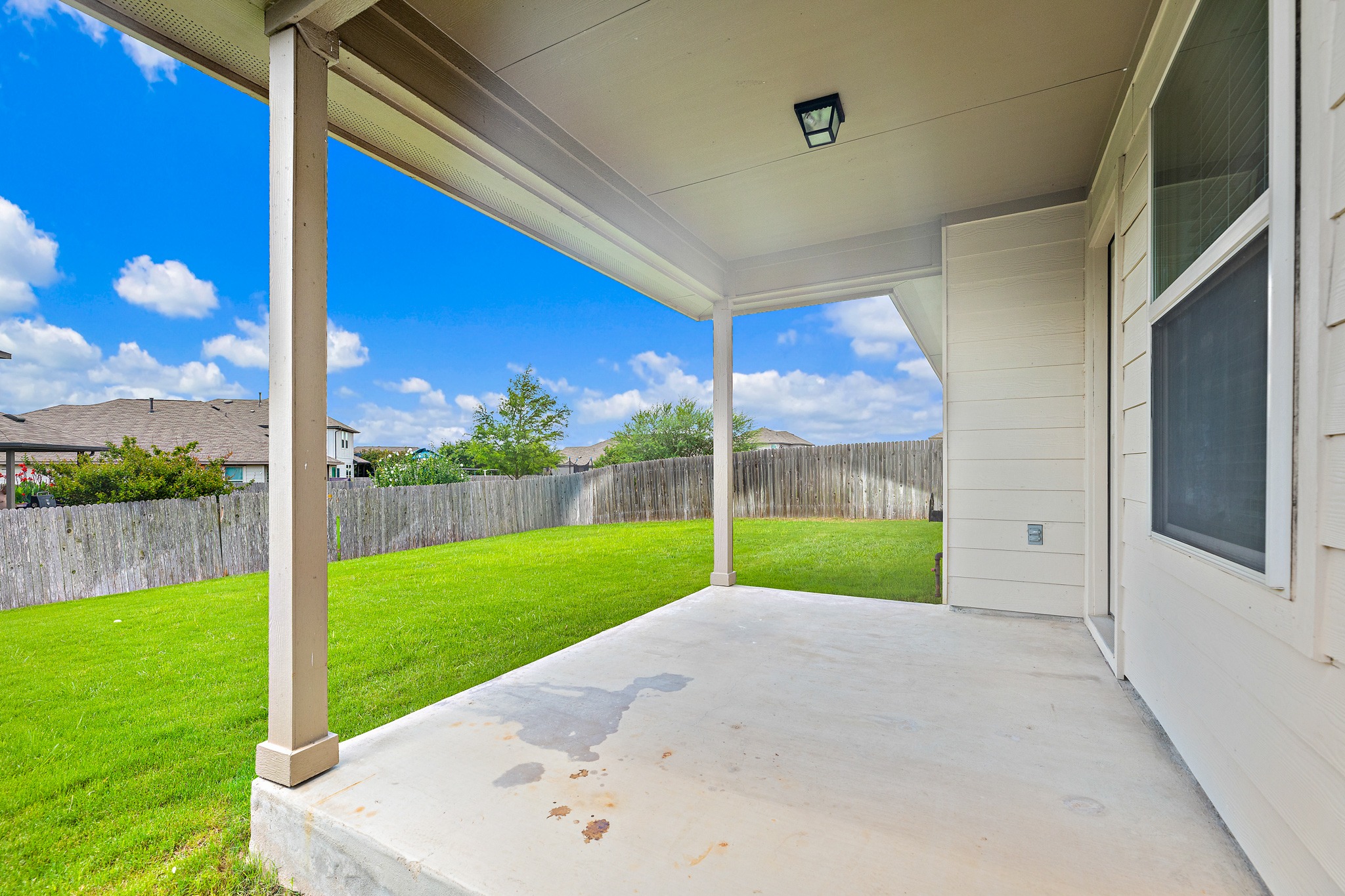 382 Limerick Road Buda, TX 78610 - Photo 19 of 20 A spacious covered patio provides a delightful outdoor living extension, overlooking the fenced backyard.