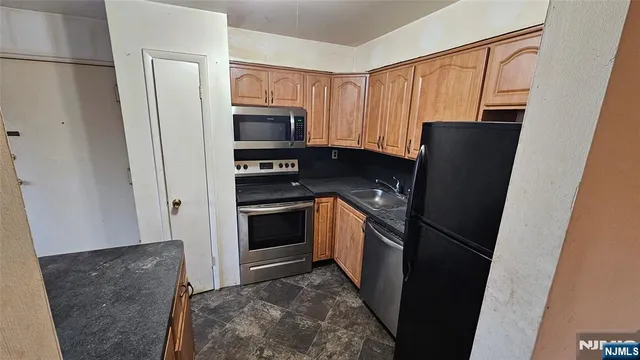 a kitchen with stainless steel appliances a refrigerator and a stove top oven