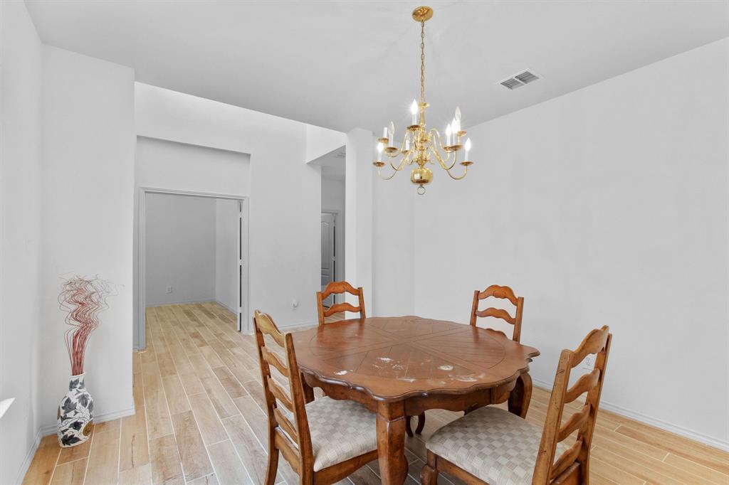 2700 Hereford Road Denton, TX 76210 - Photo 14 of 36 Dining area featuring a brass chandelier, wood-finish flooring, and bright white walls