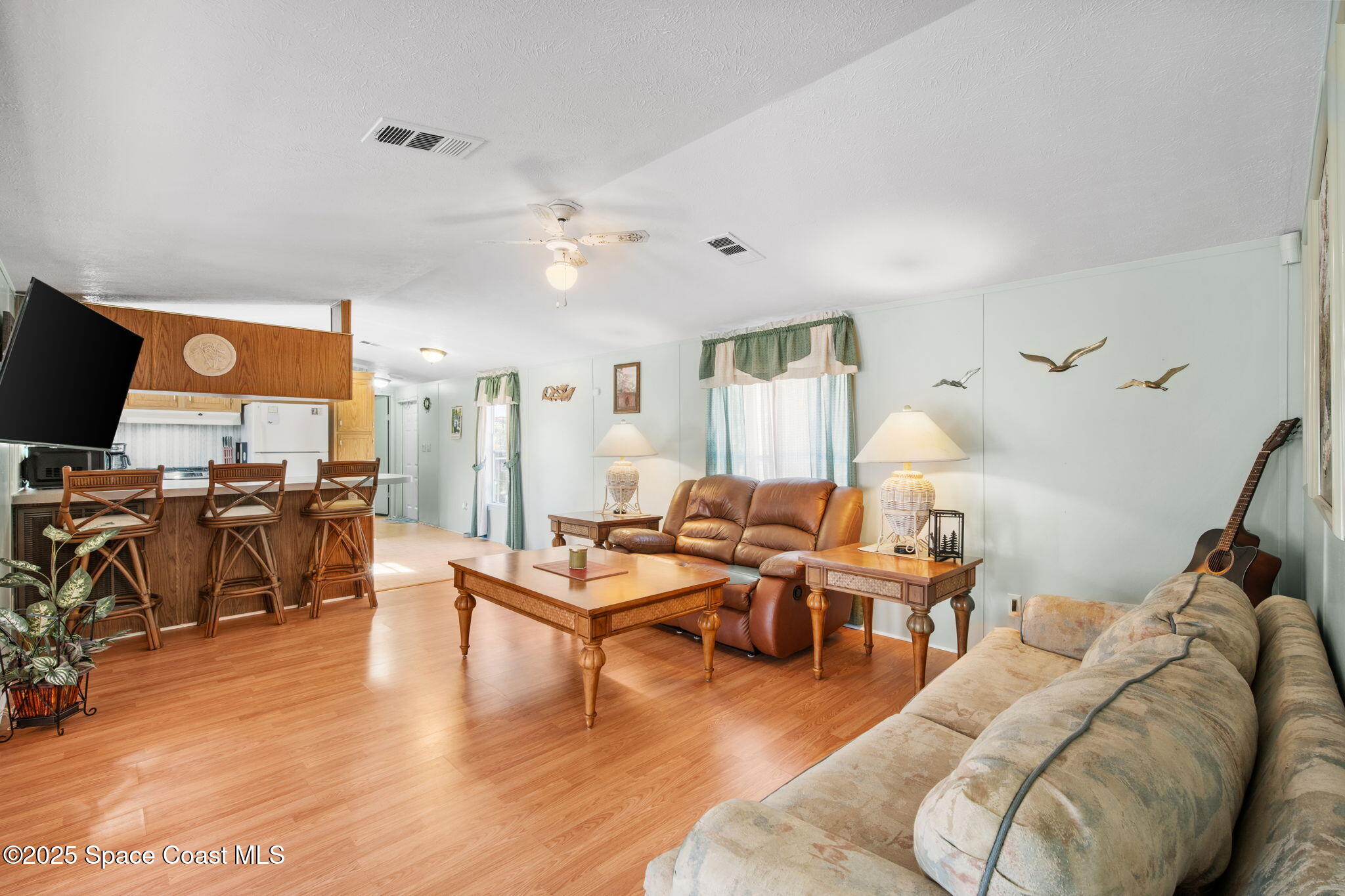 6672 Bear Trail Cocoa, FL 32926 - Photo 11 of 46 a living room with furniture kitchen view and a wooden floor