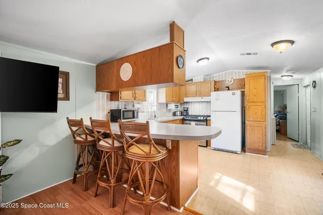 a kitchen with stainless steel appliances granite countertop a sink refrigerator and cabinets