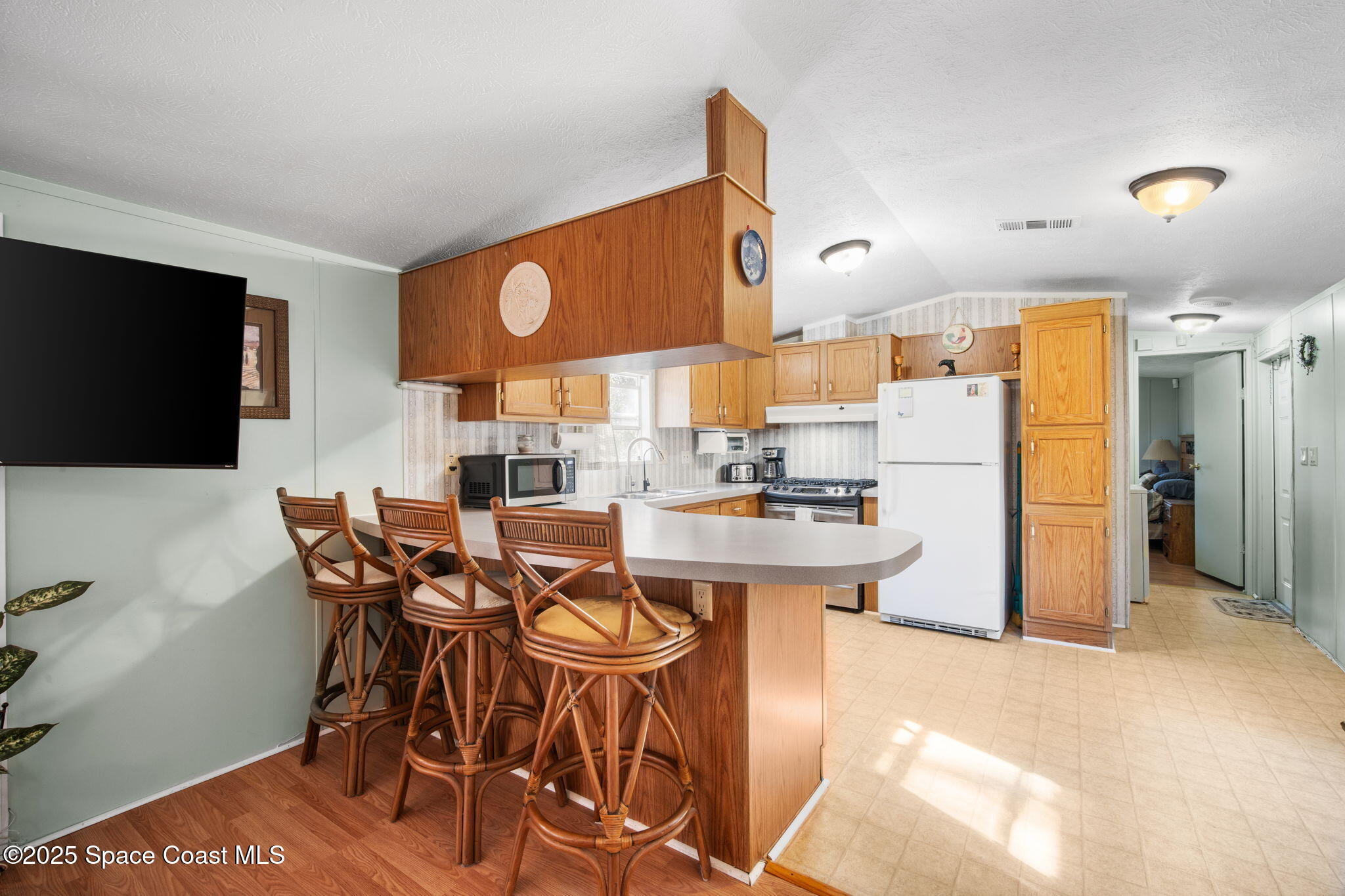6672 Bear Trail Cocoa, FL 32926 - Photo 12 of 46 a kitchen with stainless steel appliances kitchen island granite countertop a refrigerator and a stove top oven