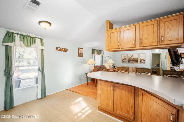 a kitchen with a sink a window and cabinets