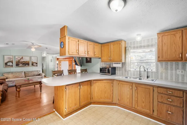 a kitchen with granite countertop a sink stainless steel appliances and cabinets
