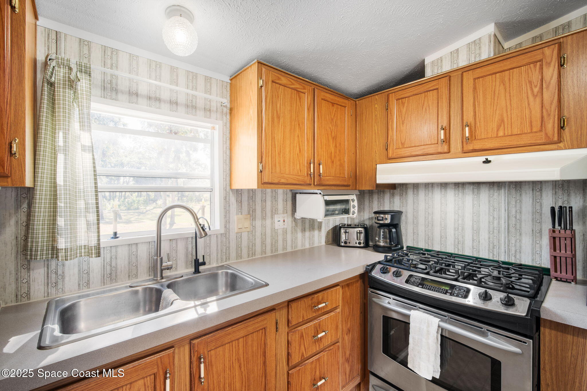 6672 Bear Trail Cocoa, FL 32926 - Photo 16 of 46 a kitchen with granite countertop a sink stainless steel appliances and cabinets
