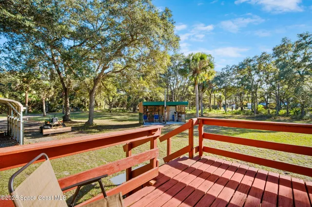 a backyard of a house with barbeque oven table and chairs