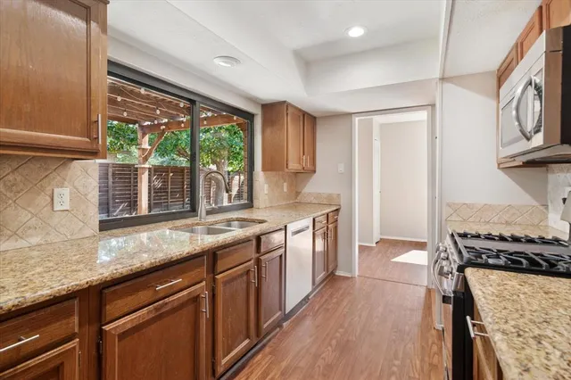 a kitchen with stainless steel appliances granite countertop a stove and a sink