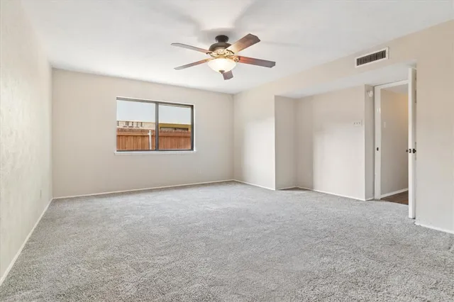an empty room with chandelier fan