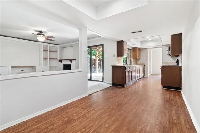 a view of a kitchen with wooden floor and electronic appliances