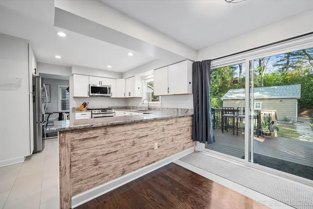 a large kitchen with kitchen island a large window cabinets and stainless steel appliances