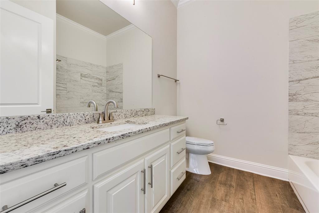 8841 Creek Run Road, Unit 403 Fort Worth, TX 76120 - Photo 20 of 26 a bathroom with a granite countertop sink a toilet and a mirror