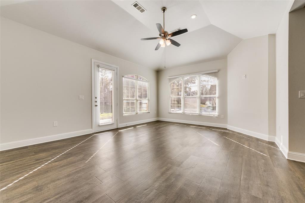 8841 Creek Run Road, Unit 403 Fort Worth, TX 76120 - Photo 6 of 26 an empty room with wooden floor chandelier fan and windows