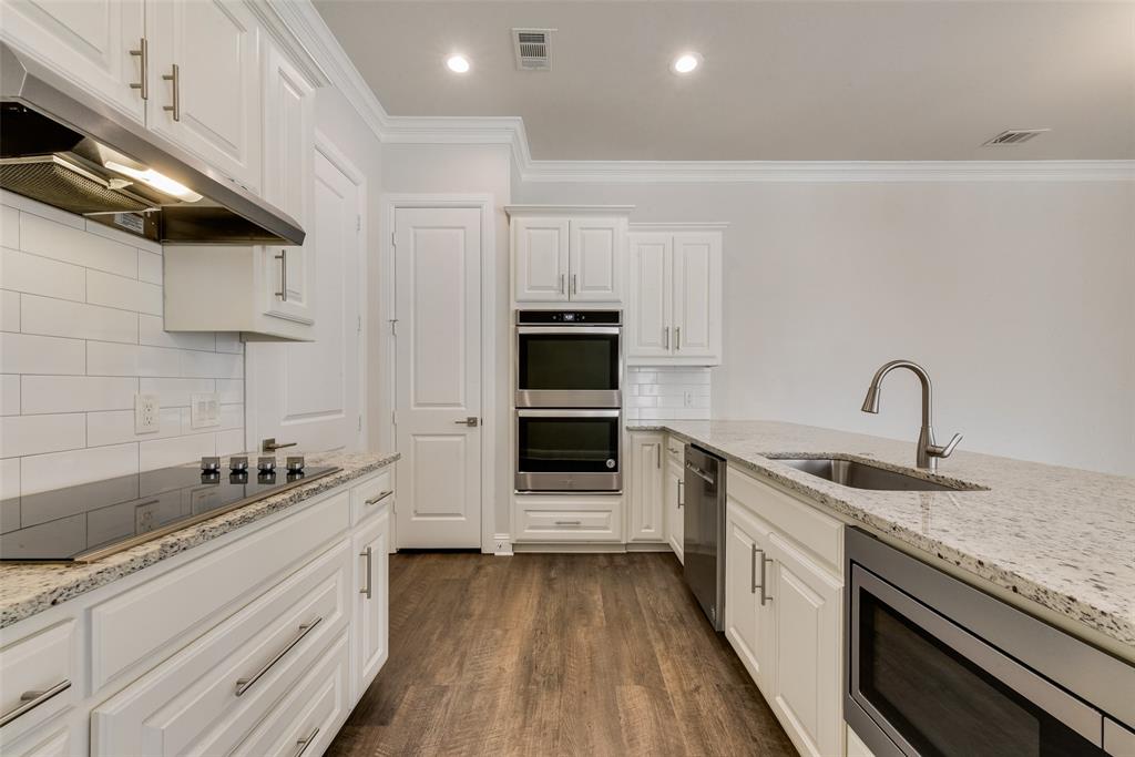 8841 Creek Run Road, Unit 403 Fort Worth, TX 76120 - Photo 10 of 26 a kitchen with stainless steel appliances kitchen island granite countertop a sink and cabinets