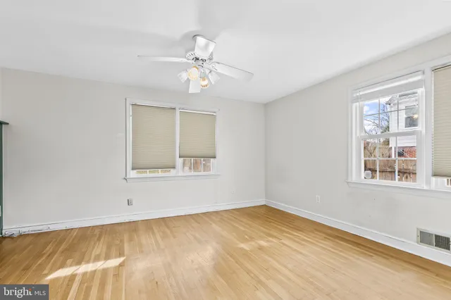 a view of an empty room with closet and fan
