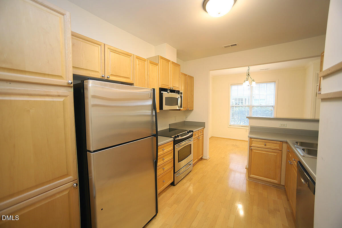 3161 Hemlock Forest Circle, Unit 101 Raleigh, NC 27612 - Photo 10 of 21 a kitchen with stainless steel appliances granite countertop a refrigerator and a stove