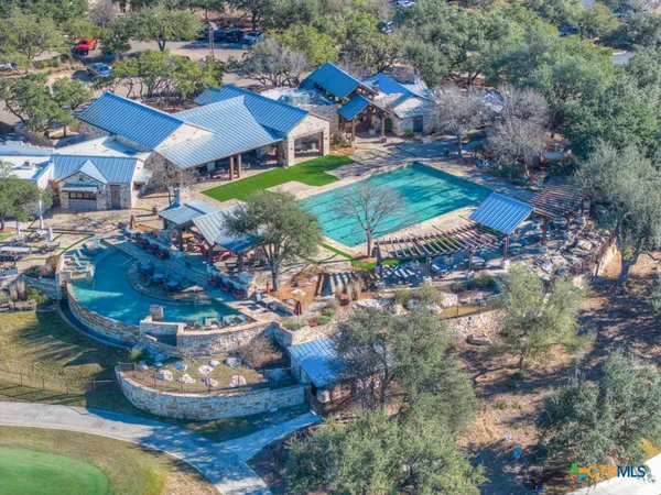 a view of a swimming pool with lawn chairs and plants