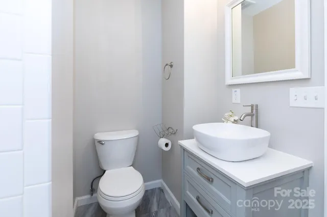 a bathroom with a sink a toilet and a mirror