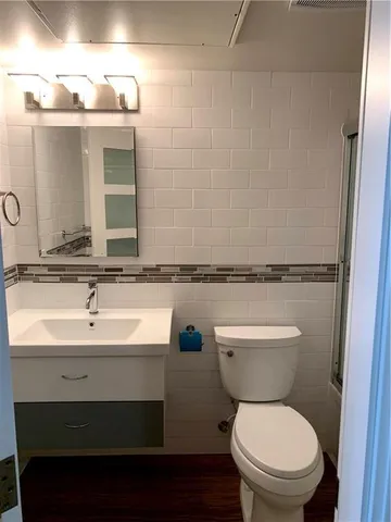 a bathroom with a toilet a sink and mirror