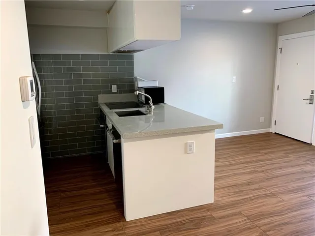 a utility room with wooden floor washer and dryer