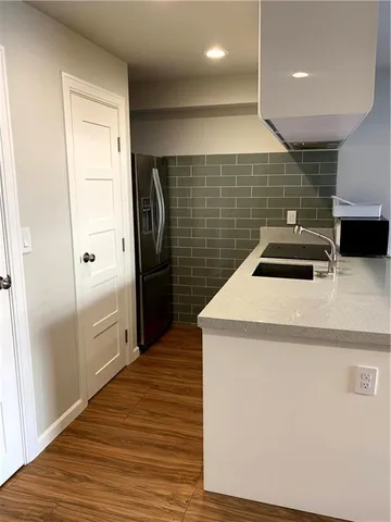 a kitchen with a sink and wooden floor