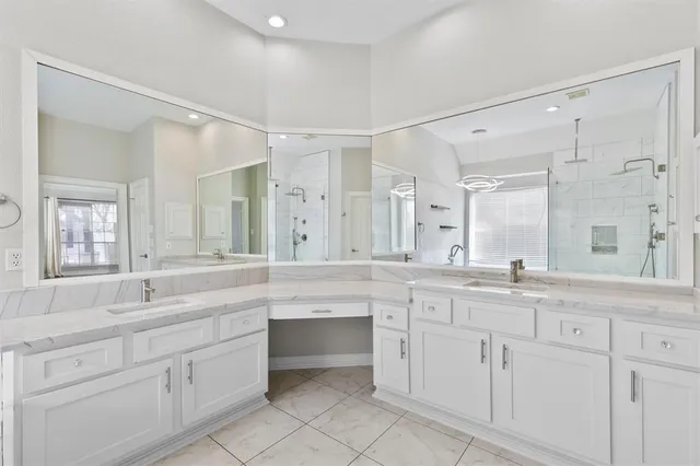 a large white bathroom with a sink mirror and a bathtub