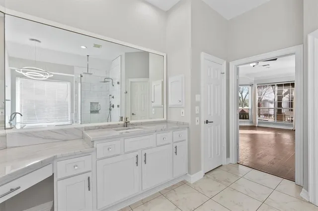 a spacious bathroom with a granite countertop sink a mirror and a