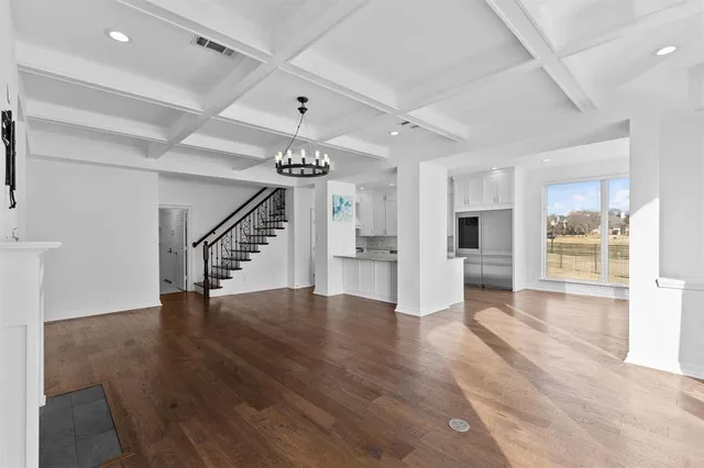 an empty room with wooden floor and staircase