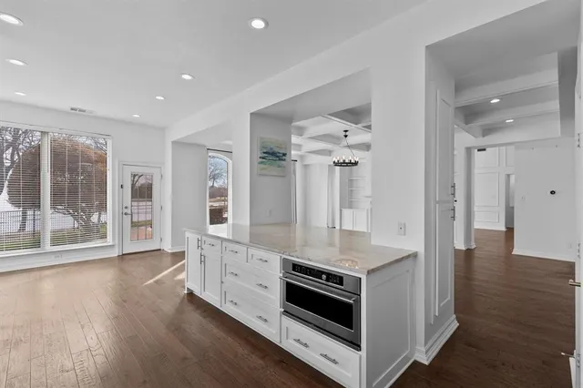 a kitchen with stainless steel appliances granite countertop a stove and a white cabinets