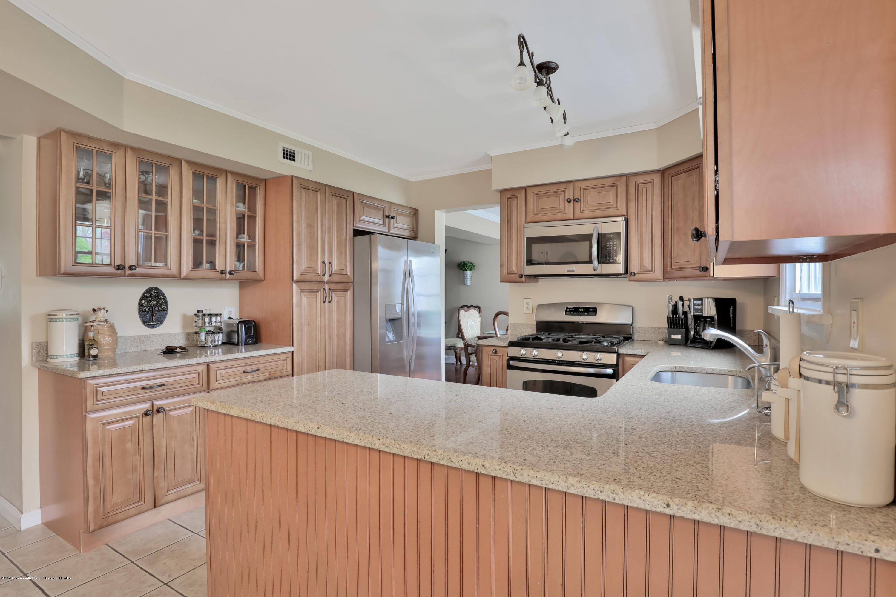 24 Starlight Road Howell, NJ 07731 - Photo 8 of 26 a kitchen with granite countertop a stove top oven a sink dishwasher and a refrigerator with wooden cabinets