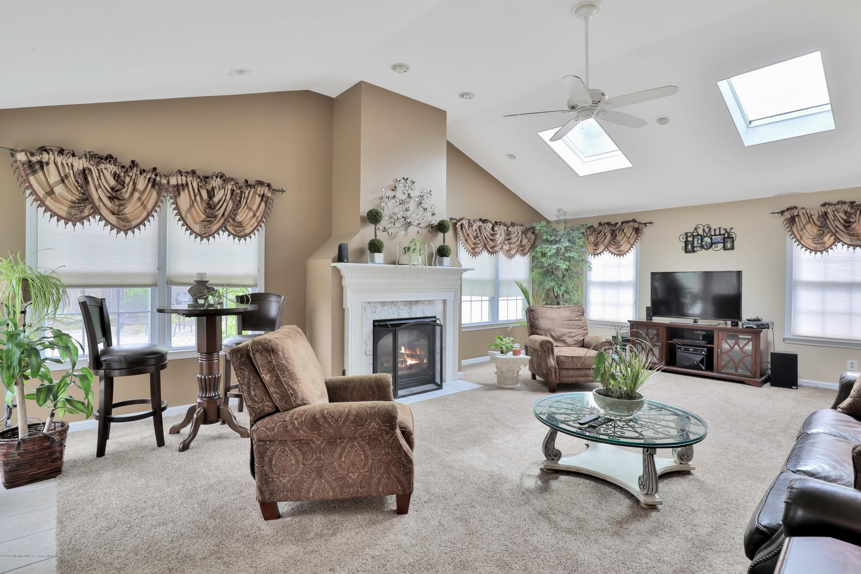 24 Starlight Road Howell, NJ 07731 - Photo 10 of 26 a living room with furniture a fireplace and a flat screen tv