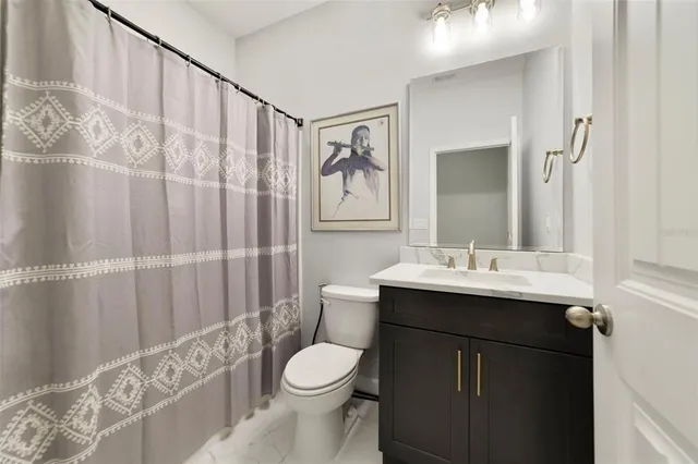 a bathroom with a sink a toilet and shower curtain