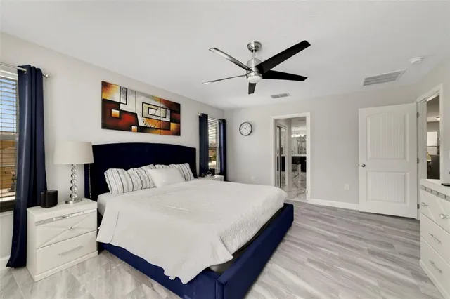 a bedroom with a large bed and a chandelier