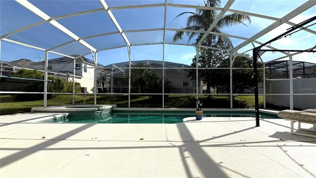 a view of swimming pool with yard in front of it