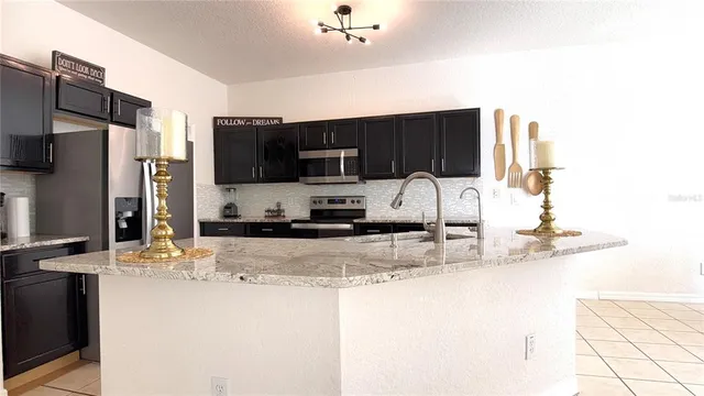 a kitchen with stainless steel appliances granite countertop a sink refrigerator and microwave