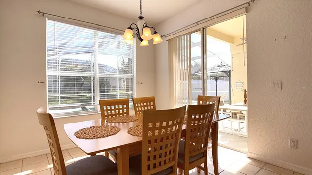 a dining room with furniture a chandelier and wooden floor