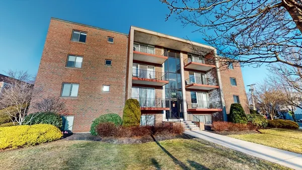 a front view of a residential apartment building with a yard