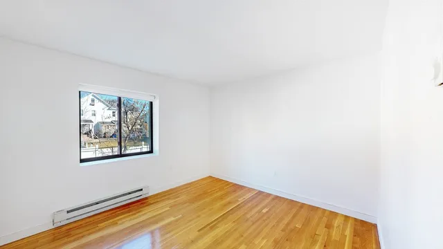 a view of a room with wooden floor and a window